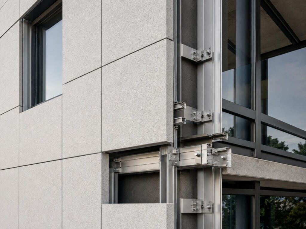 Close-up of lightweight facade panels with metal framing and anchoring details for earthquake-resilient building design