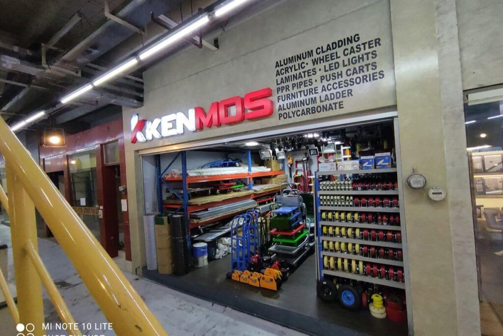 KENMOS store displaying acrylic sheets, aluminum cladding, ladders, carts, casters, and other construction materials