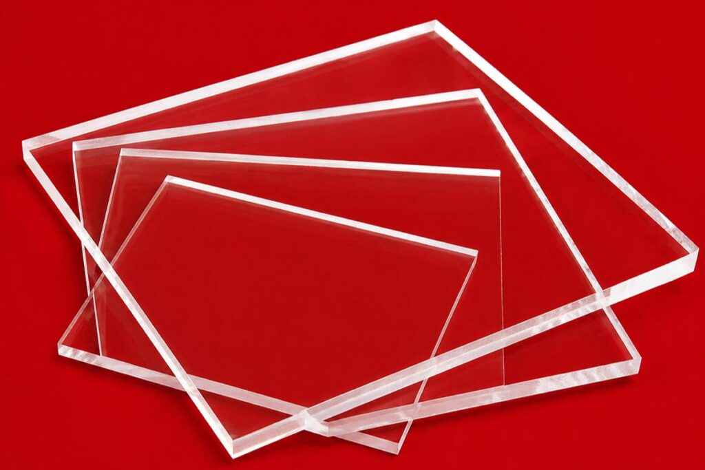 Clear acrylic sheets in different sizes and thicknesses arranged on a bright red background